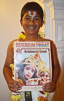Young boy holding copy of Hinduism Today